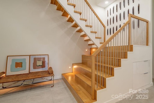stairs featuring tile patterned floors and a towering ceiling