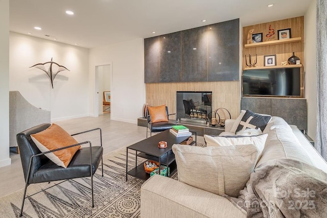living room featuring recessed lighting, baseboards, built in features, and a large fireplace