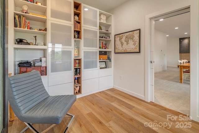sitting room featuring light wood-style floors, baseboards, and recessed lighting
