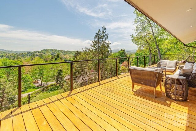deck with a wooded view and an outdoor hangout area