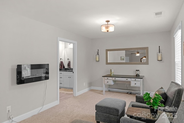 living room featuring visible vents, a ceiling fan, baseboards, and light carpet