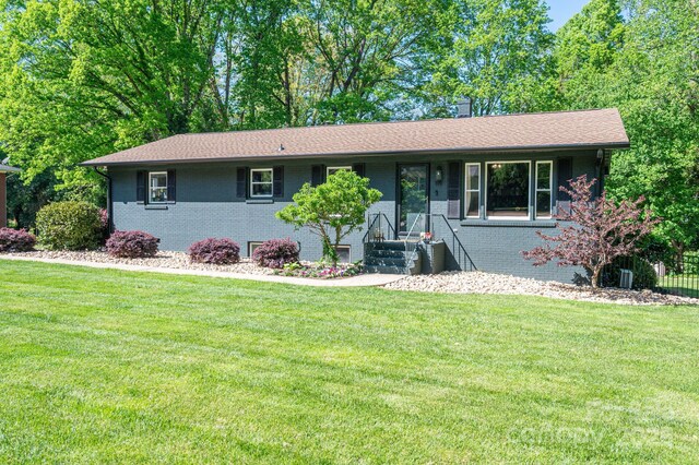 single story home with brick siding and a front lawn