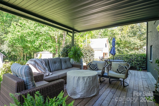 wooden deck with outdoor lounge area, a storage unit, and an outdoor structure