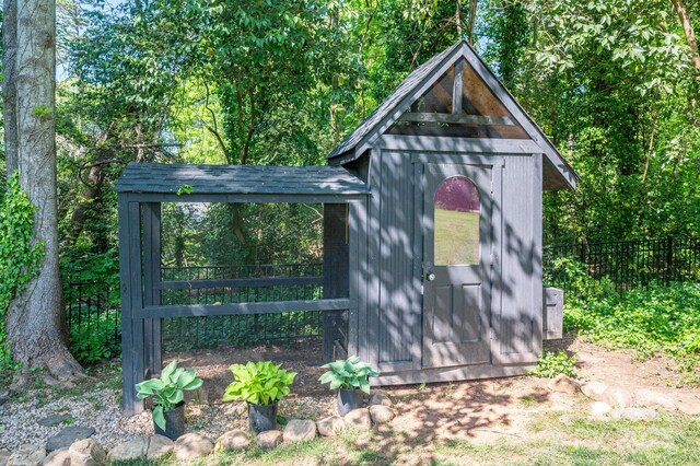 view of outdoor structure with an outbuilding and fence
