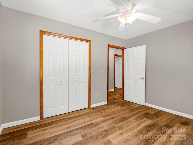 2304 Mountain Page Rd, Saluda, NC 28773 - unfurnished bedroom with baseboards, ceiling fan, wood finished floors, and a closet