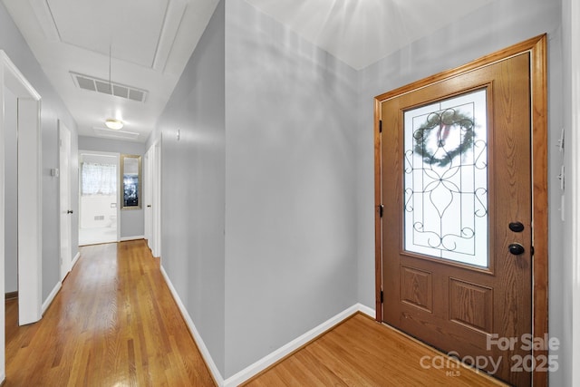 entryway featuring light wood finished floors, visible vents, and baseboards