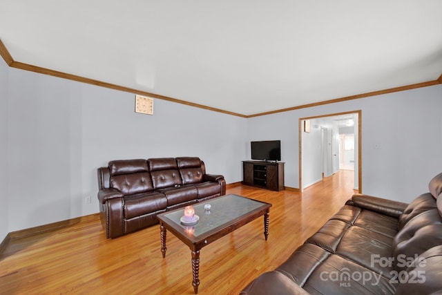 living area featuring light wood-style floors, baseboards, and crown molding