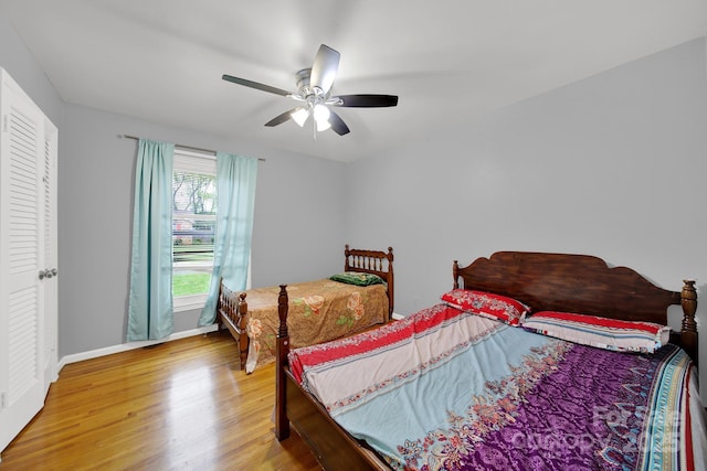 bedroom featuring light wood-style flooring, baseboards, and ceiling fan