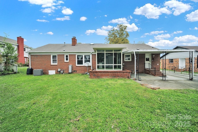 back of property featuring central AC, a sunroom, a yard, a chimney, and brick siding