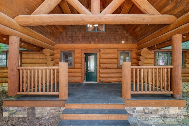 interior space with wooden ceiling, vaulted ceiling with beams, wood finished floors, and log walls