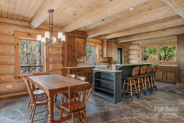 kitchen with brown cabinetry, wooden ceiling, a wealth of natural light, and log walls