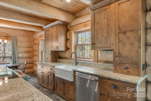 kitchen featuring light stone countertops, a sink, rustic walls, stone finish flooring, and dishwasher