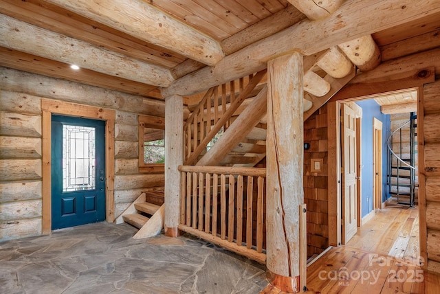 interior space with beamed ceiling, stairs, and log walls