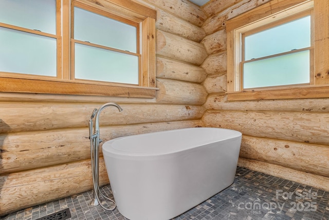 full bathroom featuring tile patterned floors, a freestanding tub, and log walls