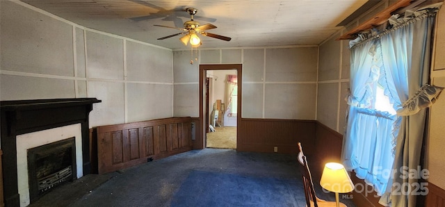 unfurnished living room featuring a ceiling fan, a fireplace, and carpet floors