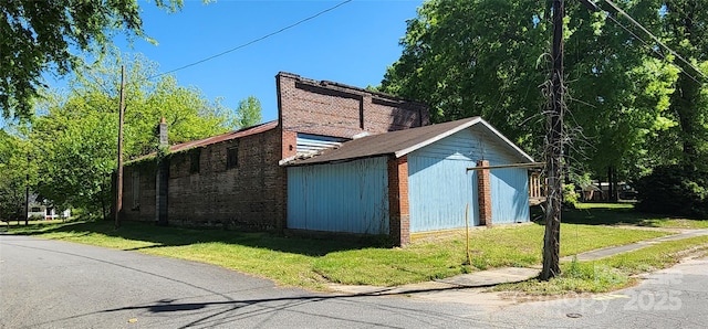 view of side of property with a yard and a garage