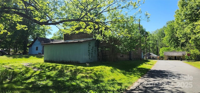 view of home's exterior with a lawn and driveway