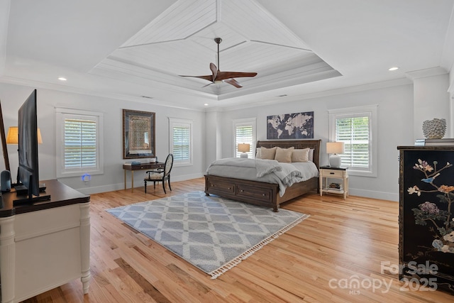 bedroom with multiple windows, a raised ceiling, and ornamental molding