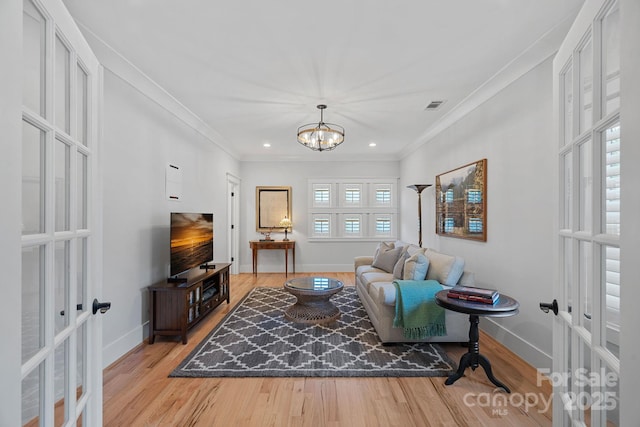 living room with wood finished floors, french doors, a notable chandelier, visible vents, and baseboards