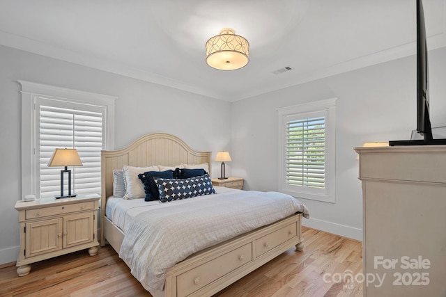 bedroom featuring light wood finished floors, baseboards, and visible vents