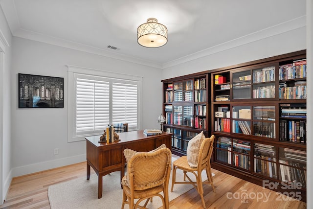 office featuring baseboards, ornamental molding, visible vents, and wood finished floors