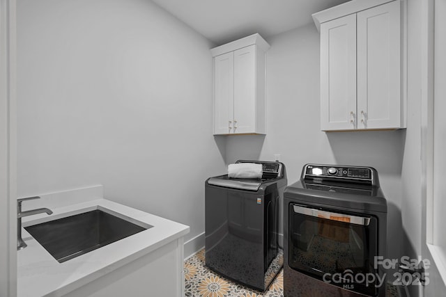 clothes washing area featuring independent washer and dryer, baseboards, cabinet space, and a sink