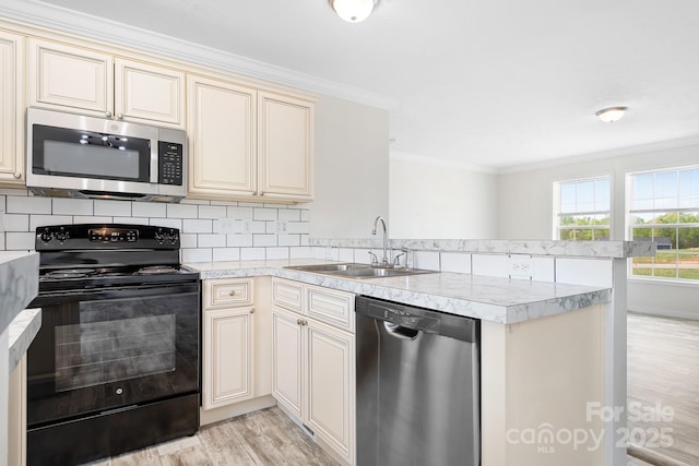 123 Pumice Dr, Statesville, NC 28625 - kitchen with stainless steel appliances, a sink, cream cabinetry, a peninsula, and light wood finished floors