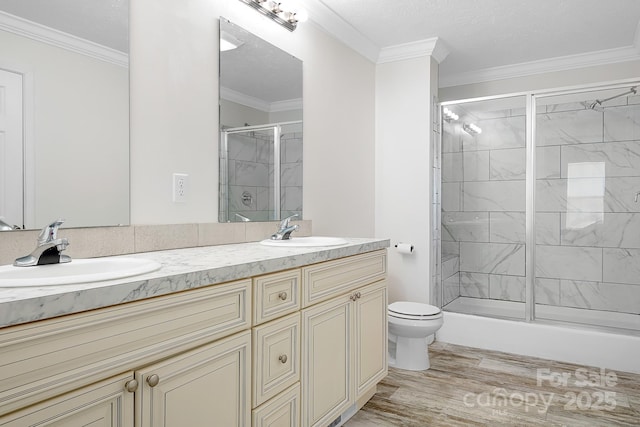 123 Pumice Dr, Statesville, NC 28625 - bathroom with double vanity, a shower with shower door, toilet, wood finished floors, and ornamental molding