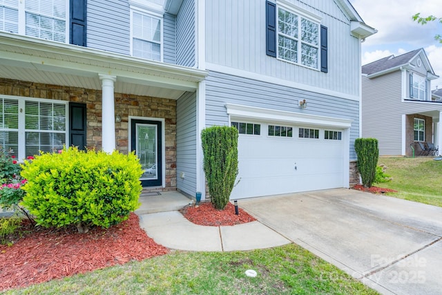 1144 Spicewood Pines Rd, Fort Mill, SC 29708 - property entrance with stone siding, a garage, covered porch, and concrete driveway