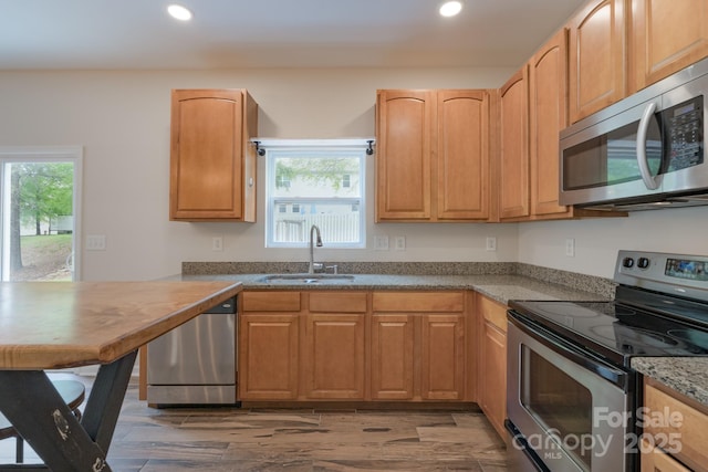 1144 Spicewood Pines Rd, Fort Mill, SC 29708 - kitchen featuring appliances with stainless steel finishes, a sink, recessed lighting, light wood-type flooring, and light stone countertops