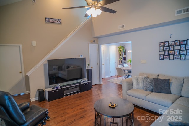 living area featuring visible vents, wood finished floors, a ceiling fan, and high vaulted ceiling