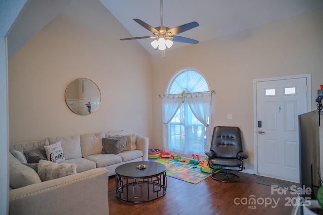 living room with wood finished floors, a ceiling fan, and high vaulted ceiling