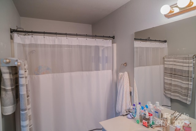 bathroom featuring a shower with shower curtain and vanity