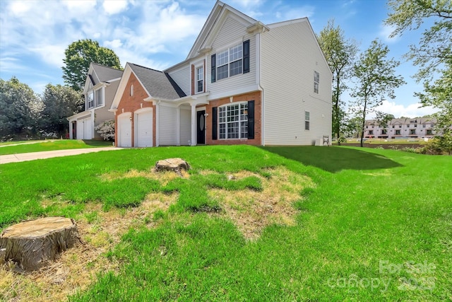 traditional home featuring an attached garage, driveway, and a front yard