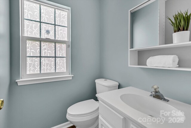 half bath featuring toilet and vanity