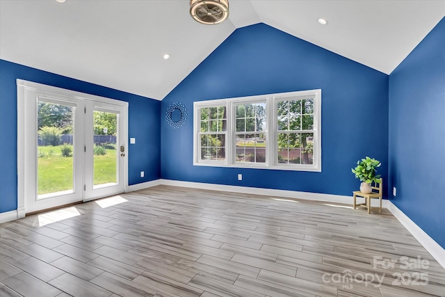 unfurnished room featuring baseboards, recessed lighting, wood finished floors, and vaulted ceiling