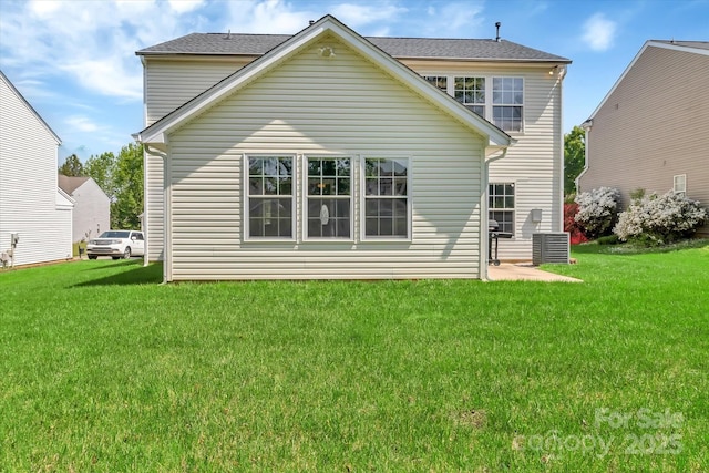 back of property with central AC unit and a yard