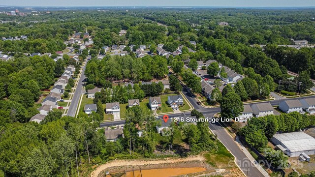 drone / aerial view with a residential view and a wooded view