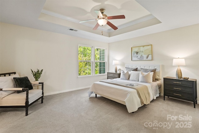 bedroom featuring visible vents, baseboards, a raised ceiling, ornamental molding, and carpet floors