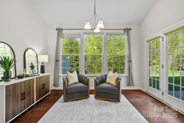 living area featuring plenty of natural light, dark wood-style floors, and an inviting chandelier