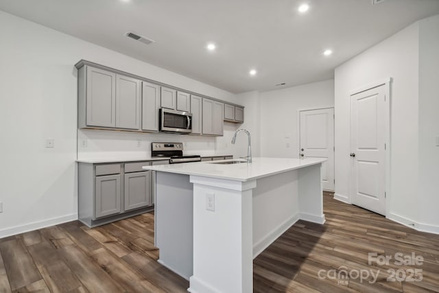 kitchen with gray cabinets, recessed lighting, dark wood-style flooring, and stainless steel appliances