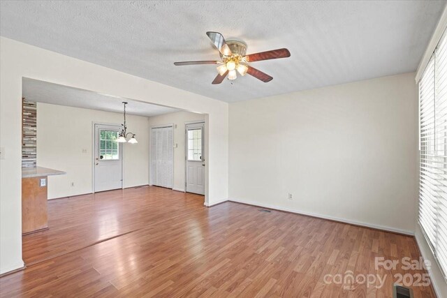 1504 Andicot Ln, Shelby, NC 28152 - unfurnished living room featuring a ceiling fan, light wood finished floors, and a chandelier