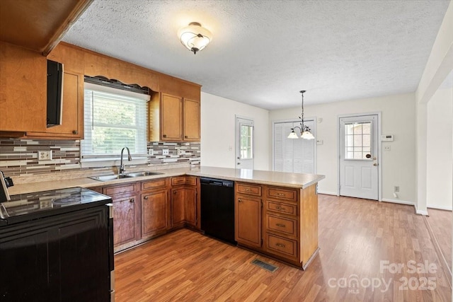 1504 Andicot Ln, Shelby, NC 28152 - kitchen with black appliances, brown cabinetry, a peninsula, light wood-type flooring, and healthy amount of natural light