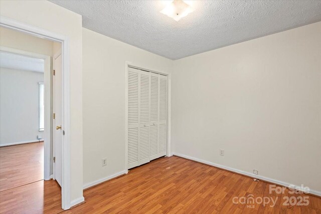 1504 Andicot Ln, Shelby, NC 28152 - unfurnished bedroom with wood finished floors, a closet, and a textured ceiling