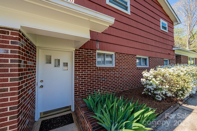 view of exterior entry with brick siding