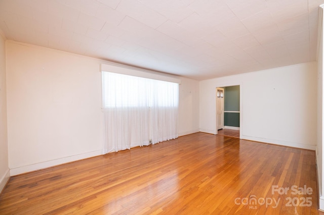 empty room featuring baseboards and hardwood / wood-style floors