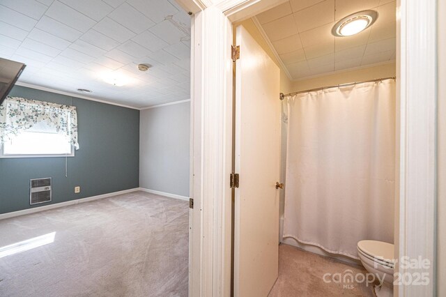 full bathroom with a shower with shower curtain, toilet, crown molding, and heating unit