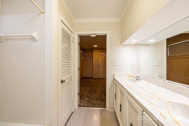 full bathroom with a shower, crown molding, double vanity, and a sink