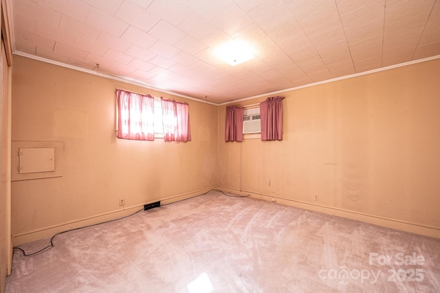 spare room featuring light colored carpet, baseboards, and ornamental molding