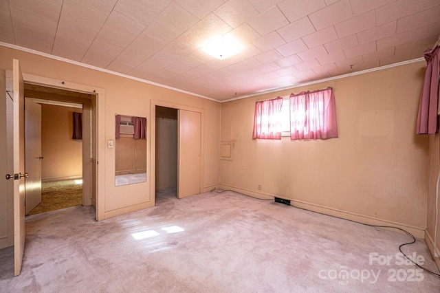 unfurnished bedroom with carpet flooring, a closet, and crown molding
